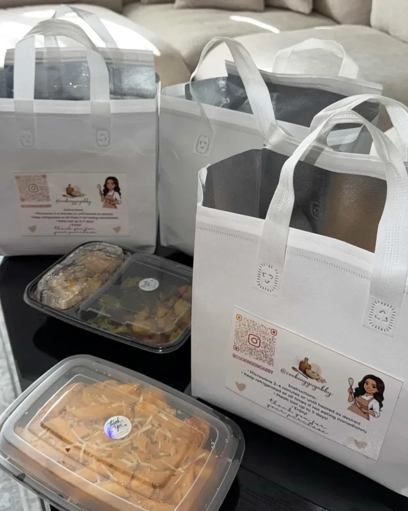White Cooking with Gabby tote bags with the reheat card, beside packed meal containers