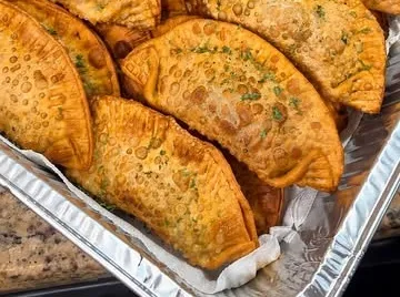 A foil tray of golden homemade empanadas